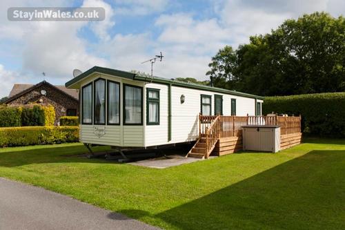 Caravan with decked terrace at Woodland Park - Vale Holiday Parks